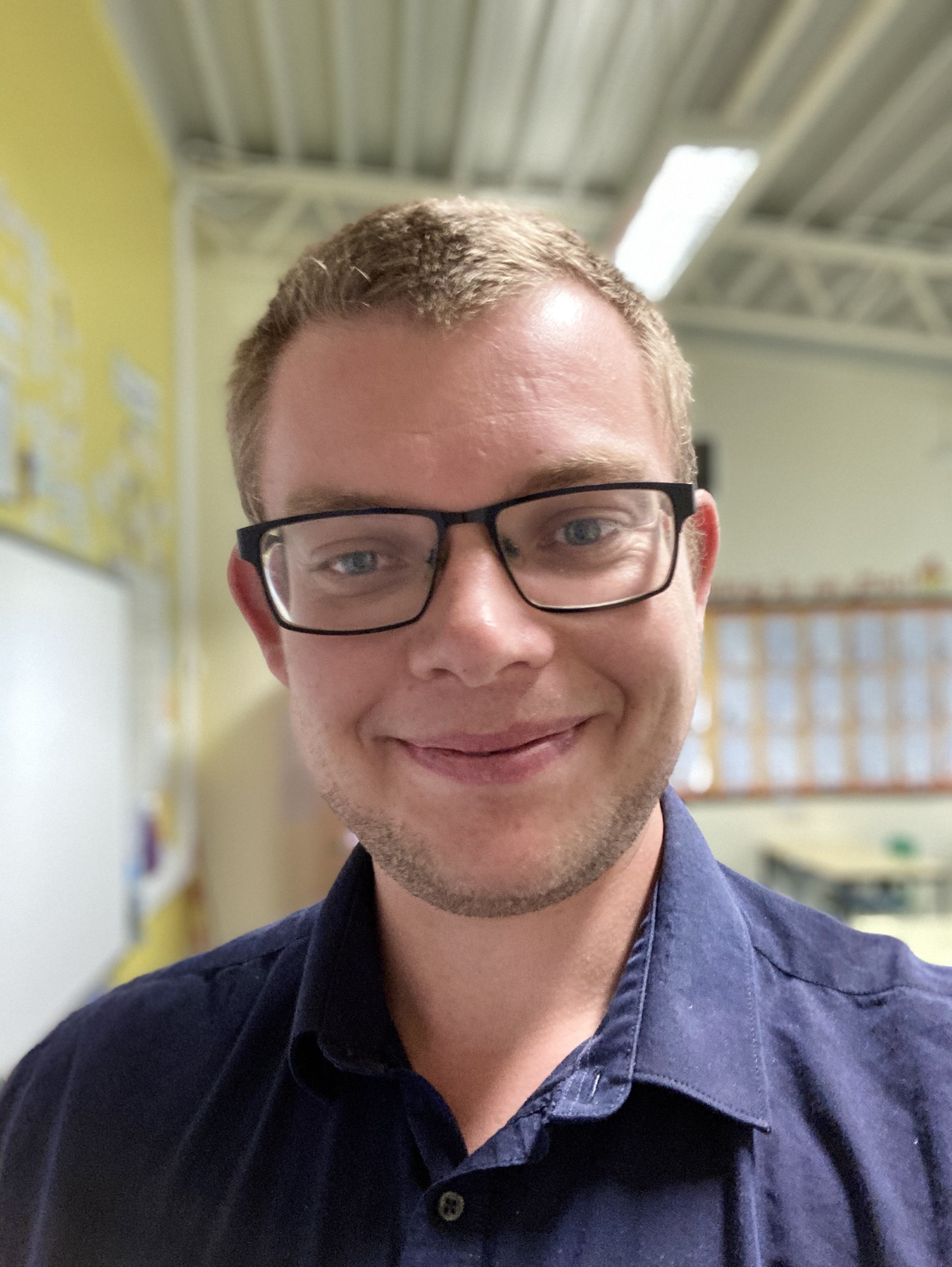 A picture of Tom Barton-Wilkes smiling at the camera